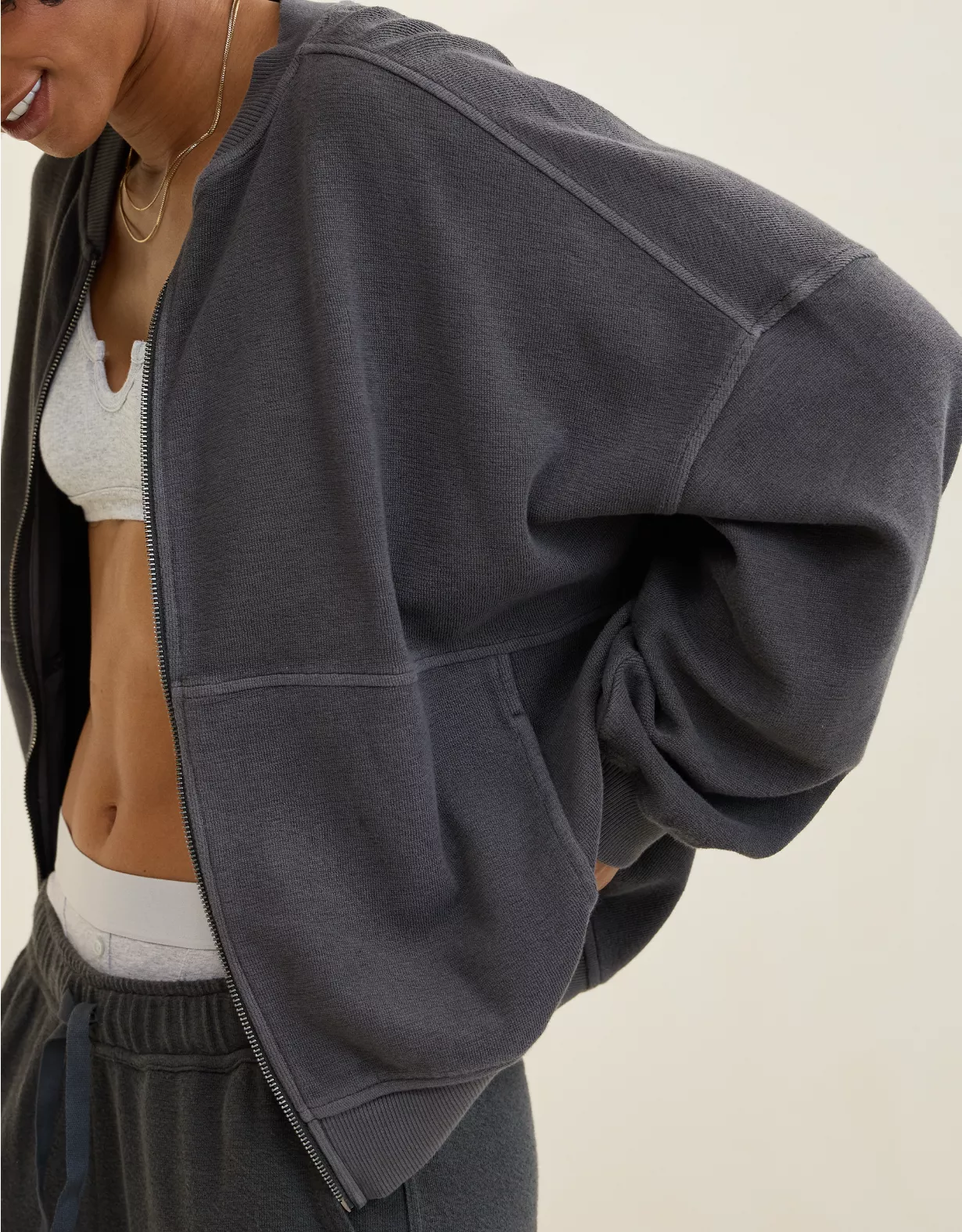 Close-up of woman wearing dark grey Aerie full zip sweatshirt