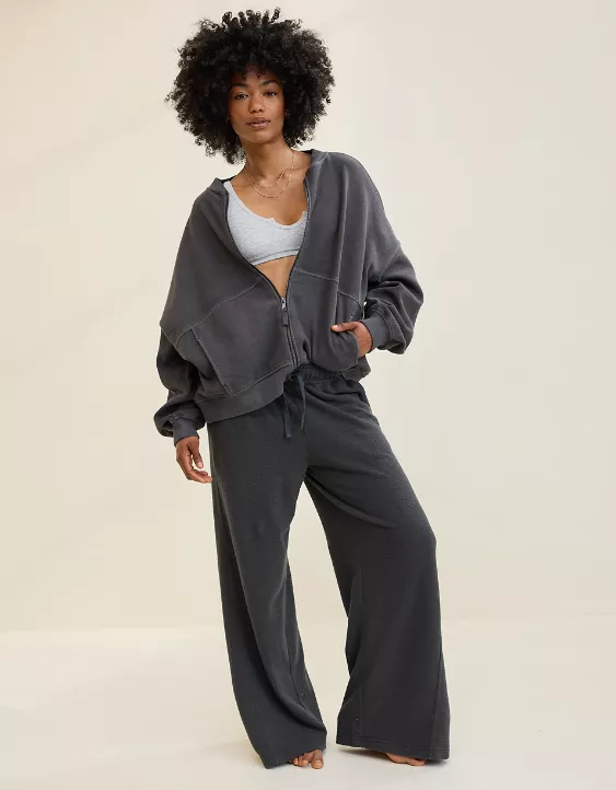 Woman wearing dark grey zip sweatshirt and matching wide-leg pants