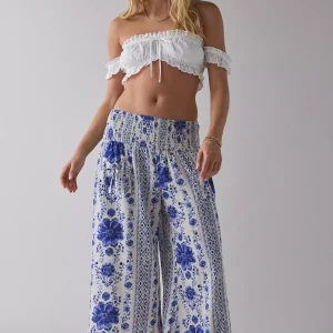 Woman wearing white smocked crop top with ruffle trim